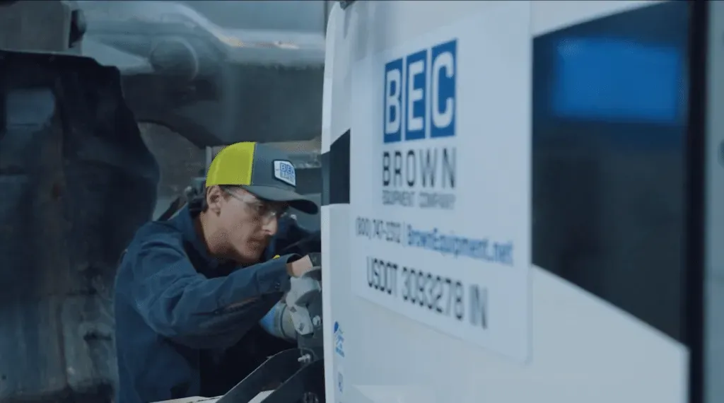 Brown Equipment Company technician performing precise equipment maintenance in a professional setting.