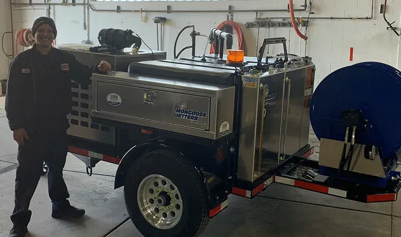 Brown Equipment Company employee standing in front of Drain Cleaning Equipment