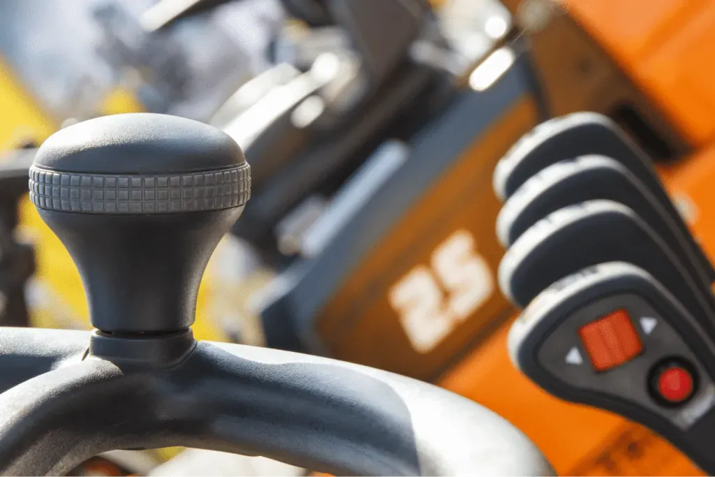 Detailed view of machinery control levers and joystick for precise operation.