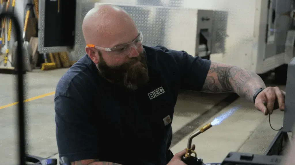Welding techniques demonstrated by a skilled craftsman using a torch in a workshop.