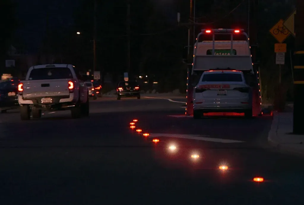 Illuminated traffic markers enhance safety and visibility on dark streets at night.
