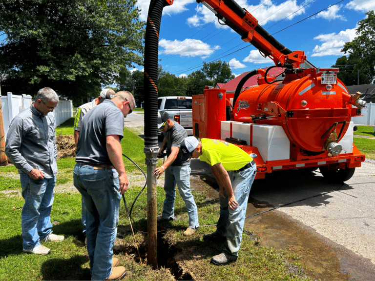 Utility crew performing excavation and repair work on a sunny day.