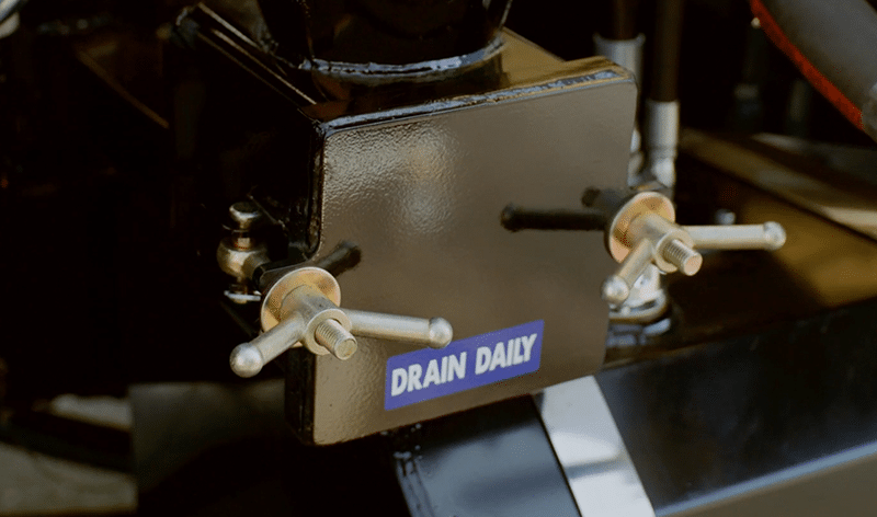 Daily drain management system on Brown Equipment Company employee standing in front of Drain Cleaning Equipment with valves for efficient water control.
