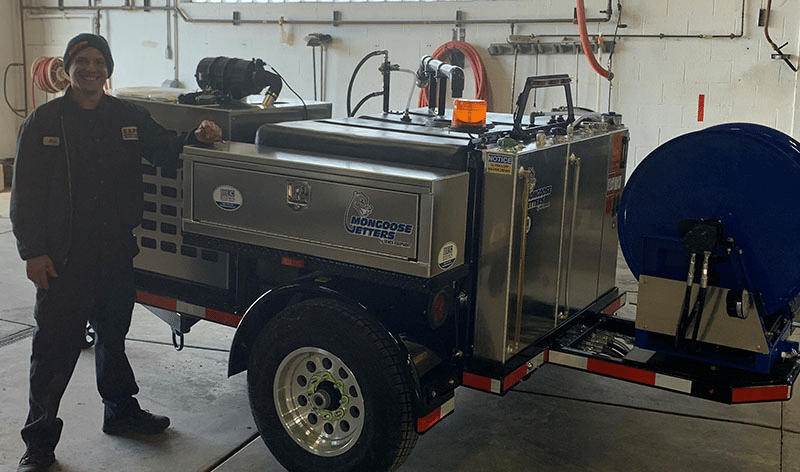 Brown Equipment Company employee standing in front of Drain Cleaning Equipment