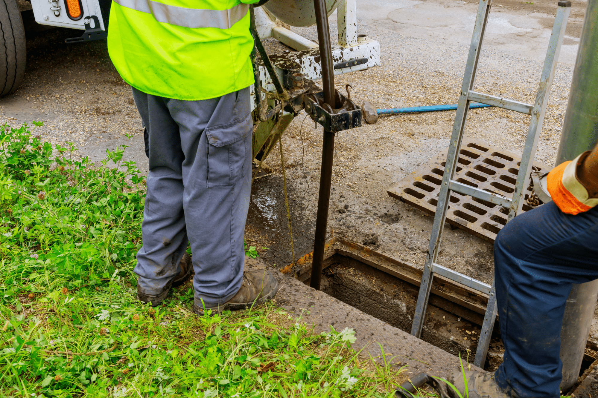 Construction worker operating machinery at a digging site. Safety gear visible.