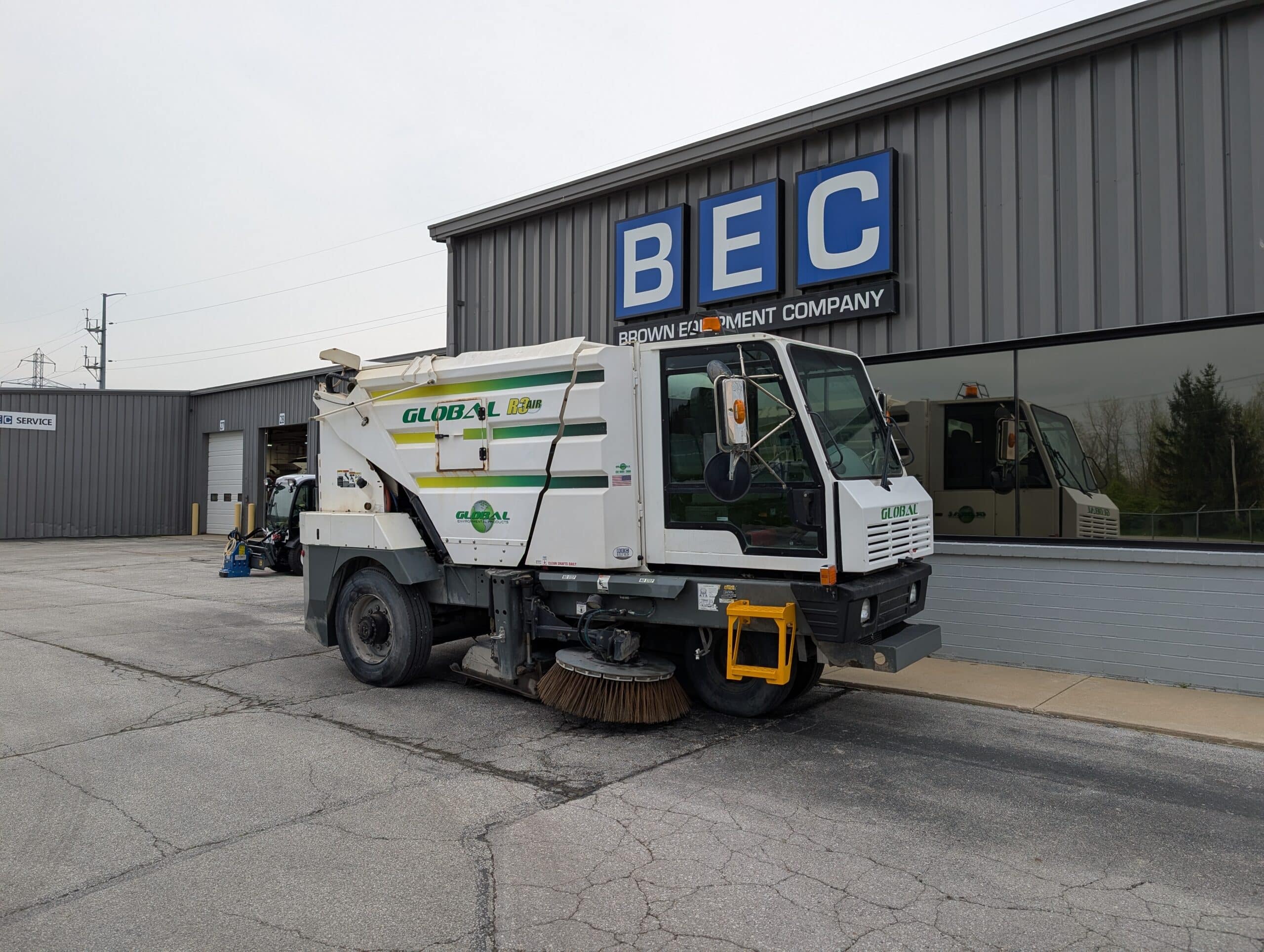 Street cleaning vehicle parked outside Brown Equipment Company, ready for service.
