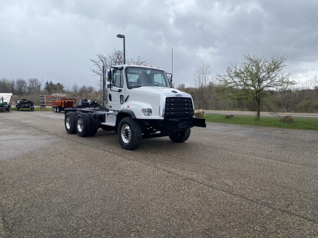 Freightliner tandem axle truck parked, showcasing robust design and utility features.