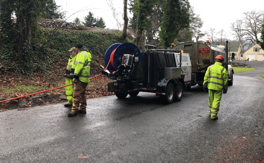 Utility crew performing essential road maintenance with specialized equipment on site.
