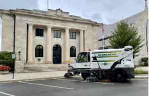 Street sweeper cleaning in front of a historic building.