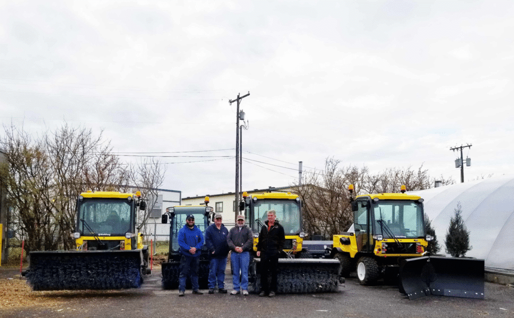 Municipal fleet management concept with snow plow operators standing with their equipment.