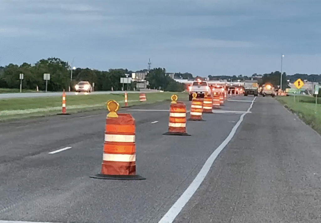 Safety orange barrels marking roadwork area on a highway for heavy equipment operations