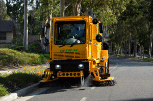 Street cleaning vehicle sweeping neighborhood roads for a cleaner community.