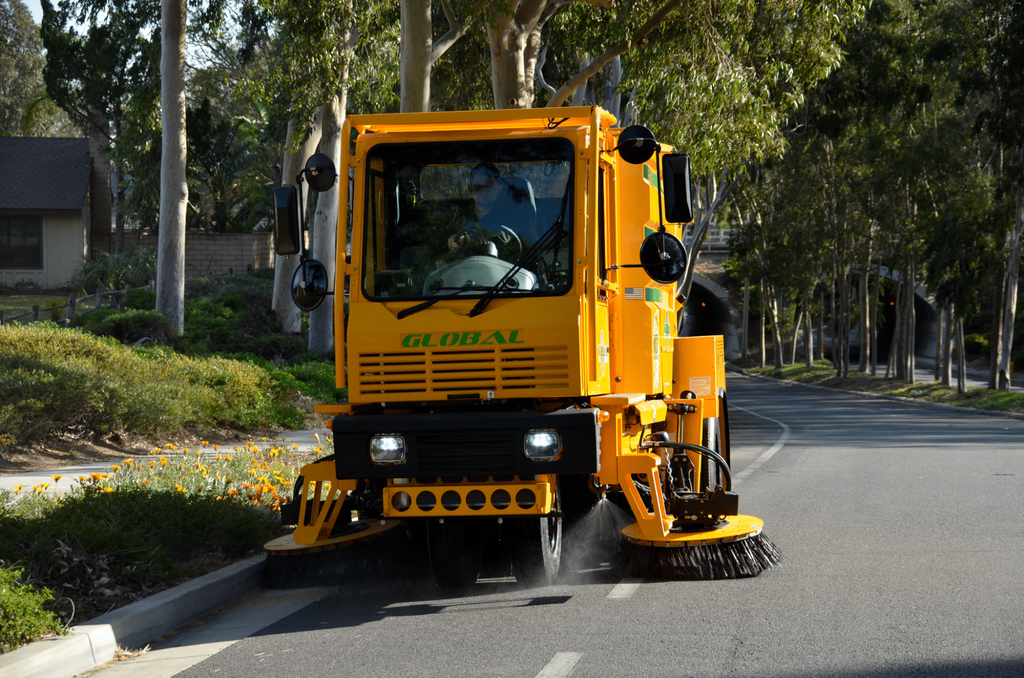 Street cleaning vehicle sweeping neighborhood roads for a cleaner community.