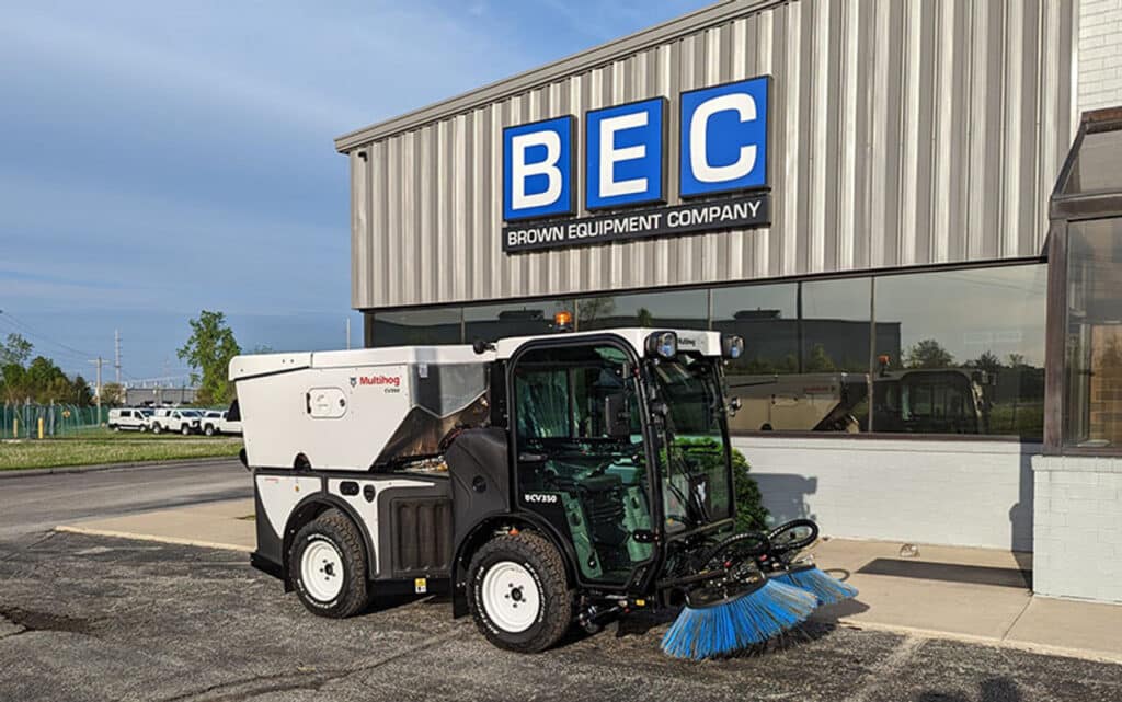 Street sweeper cleaning outside BEC Company building.