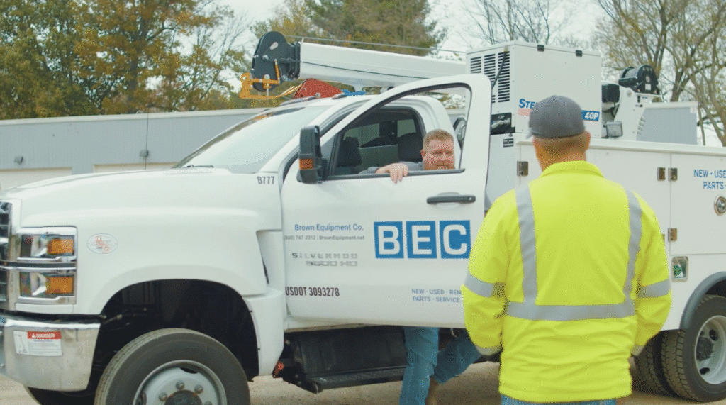 Brown Equipment Company worker getting out of a company truck to greet another