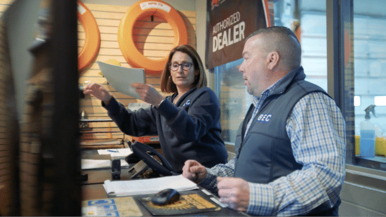 Dealership employees collaborating on customer service tasks and paperwork.