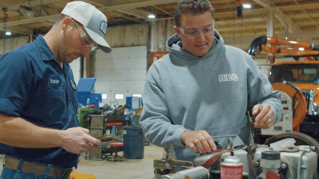 Workers collaborating on machinery repair in an industrial workshop.