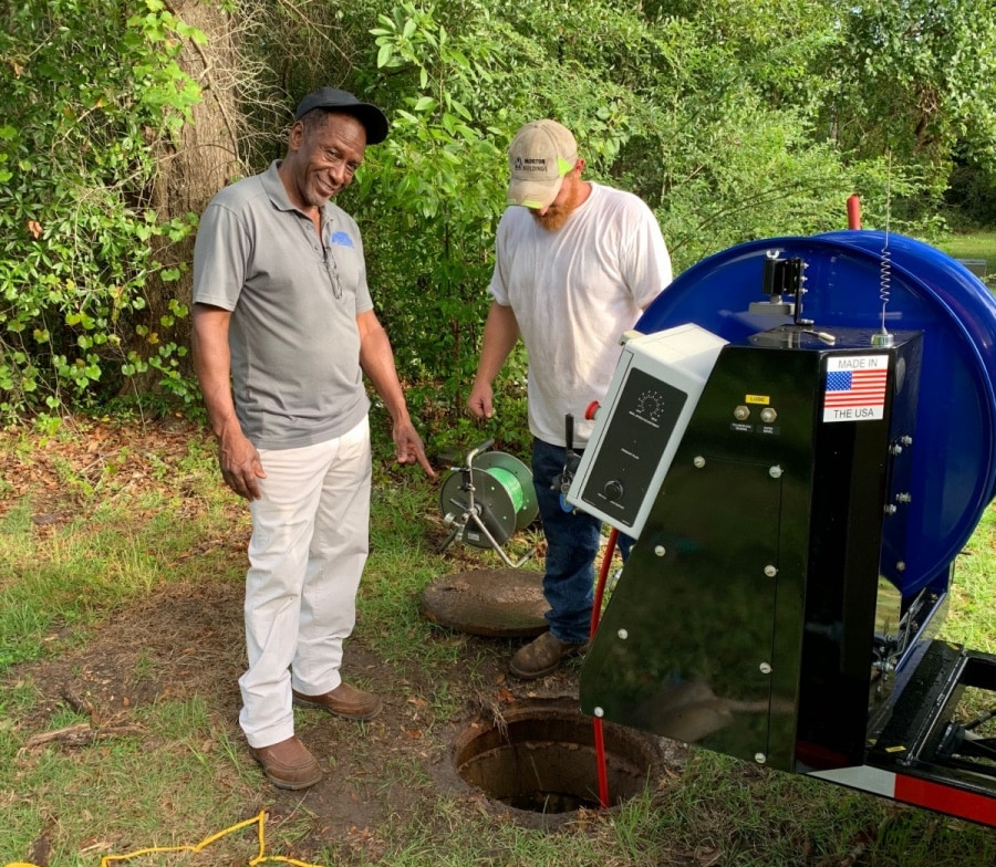 Technicians performing expert drain inspection with advanced sewer jetter equipment outdoors.