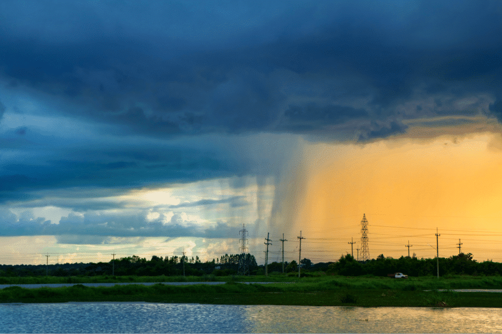 Storm clouds above a serene lake create a stunning sunset reflection.