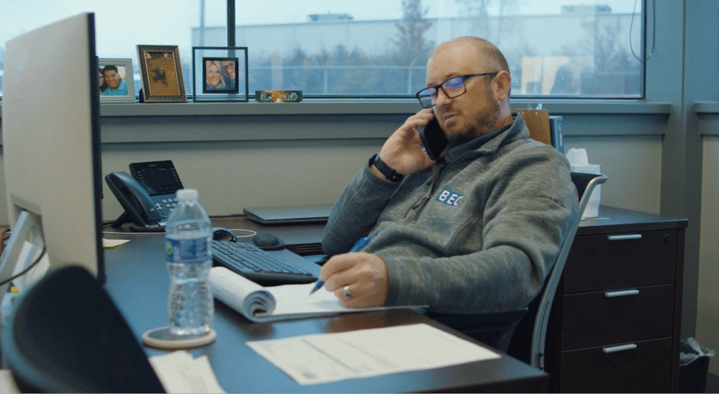 Professional taking notes on a call in a modern office.