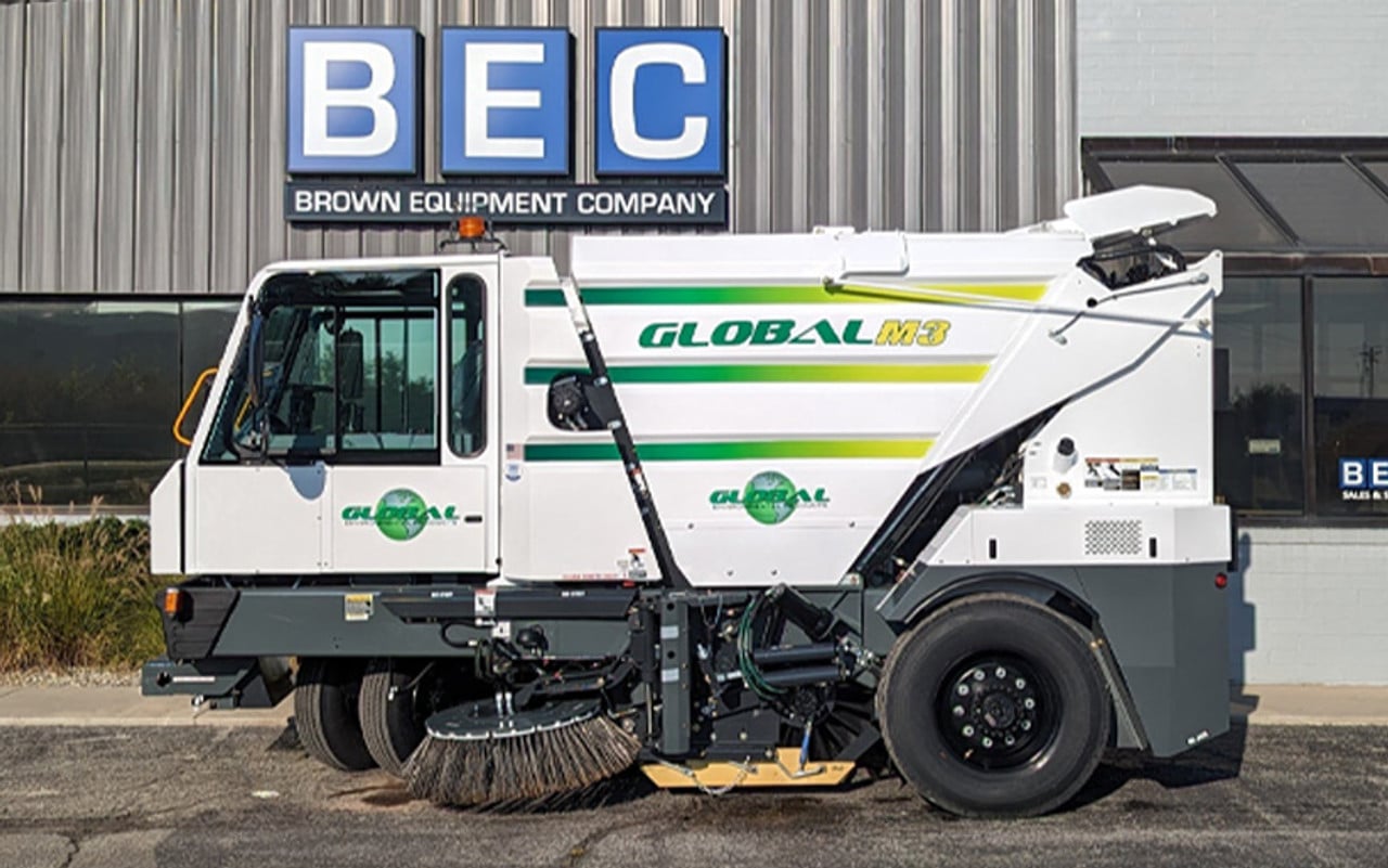 Global M3 street sweeper parked outside Brown Equipment Company, showcasing advanced cleaning technology.