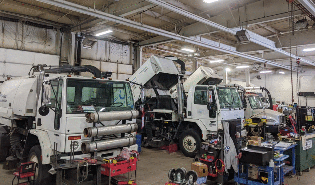 Heavy equipment undergoing maintenance in a well-equipped service shop.