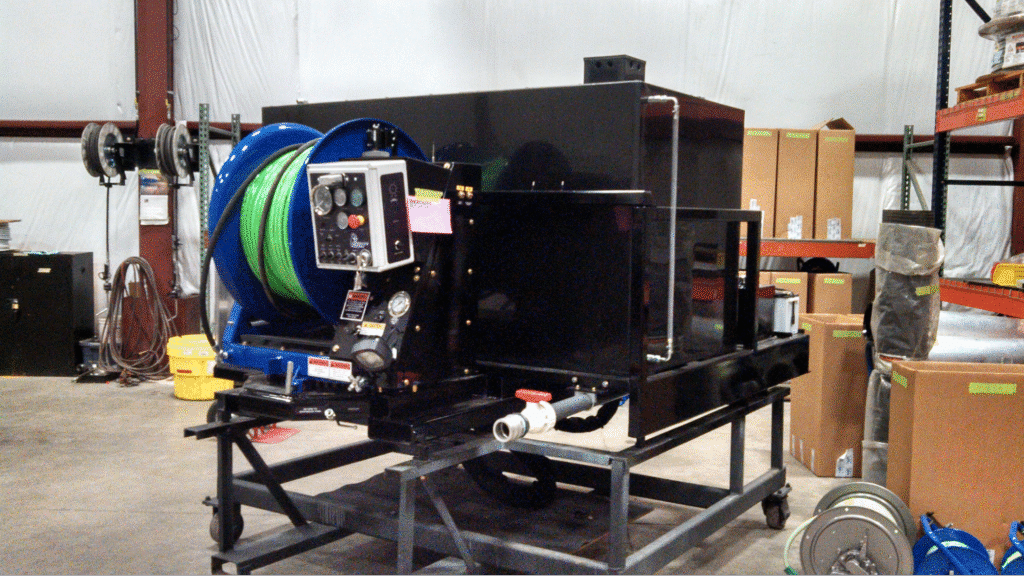 sewer jetter with hose reel showcased in a warehouse setting.