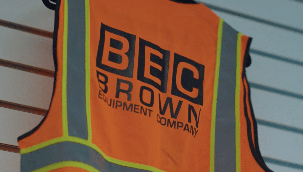Bright orange safety vest featuring BEC Brown Equipment Company logo for visibility and safety.