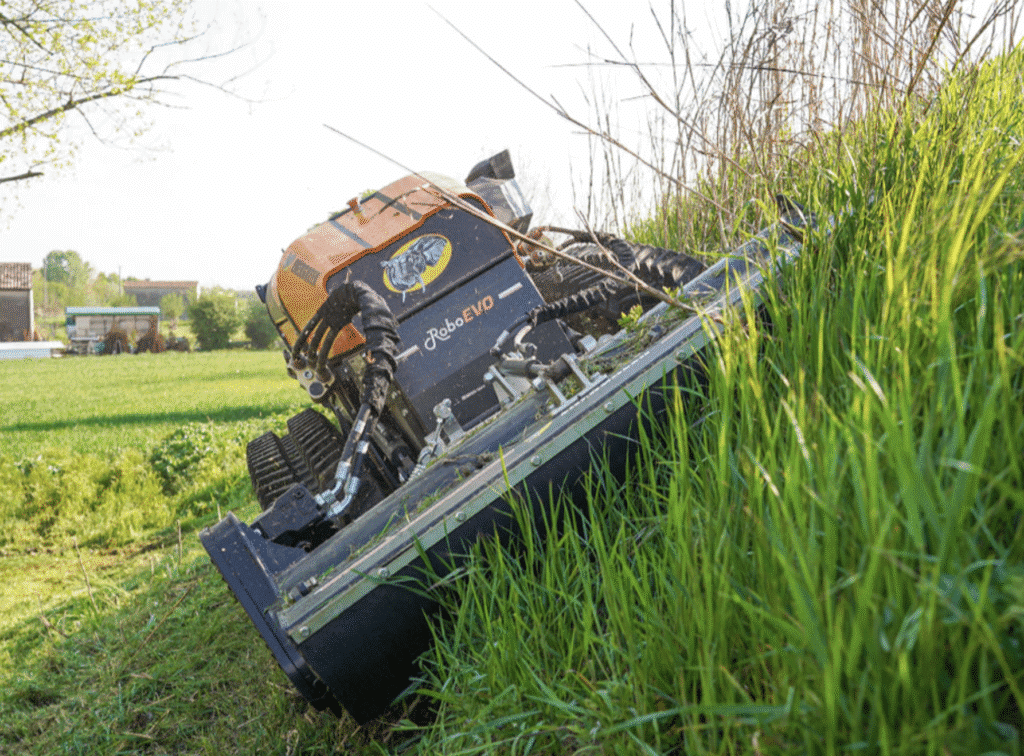 Slope mower tackling overgrown grass in a vibrant green field.