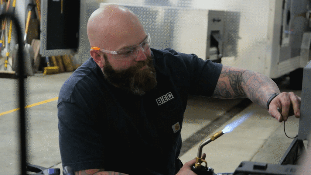 Welding techniques demonstrated by a skilled craftsman using a torch in a workshop.