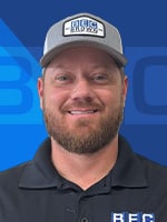 Logan Carter, Parts & Service Sales Representative in a branded cap, smiling against a blue background.