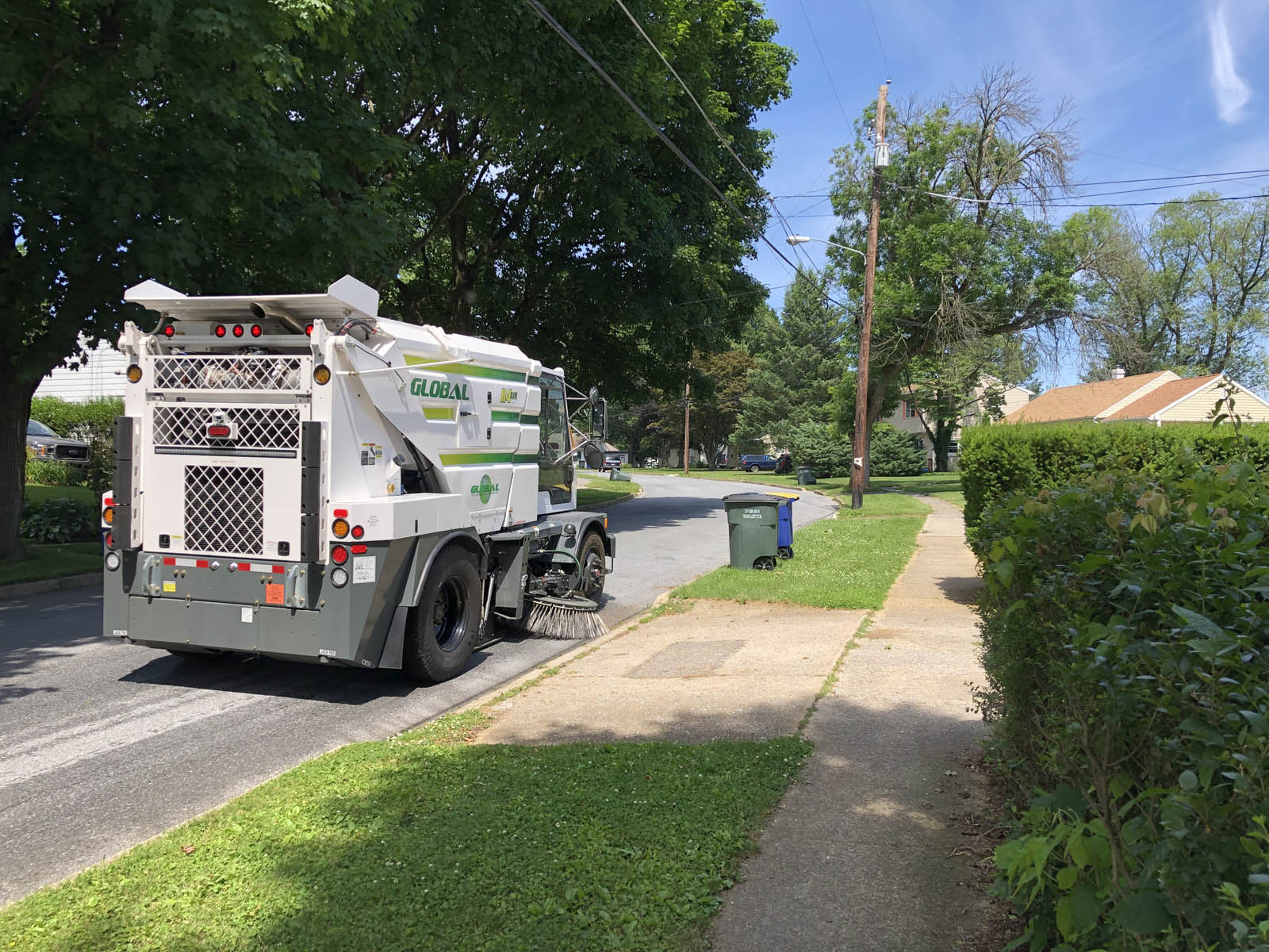 Street sweeper cleaning residential streets for a cleaner neighborhood.