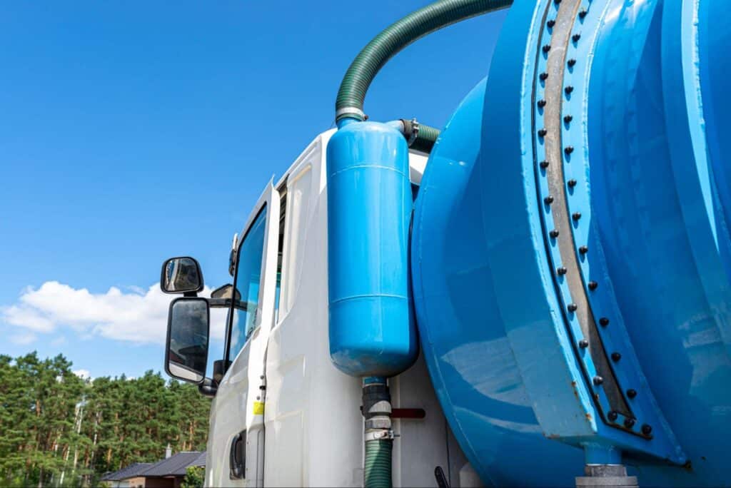 Sewer cleaning truck with tank against clear sky