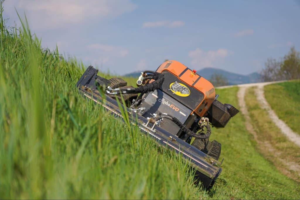 Remote control lawn mower on a steep hill, making grass trimming efficient and easy.