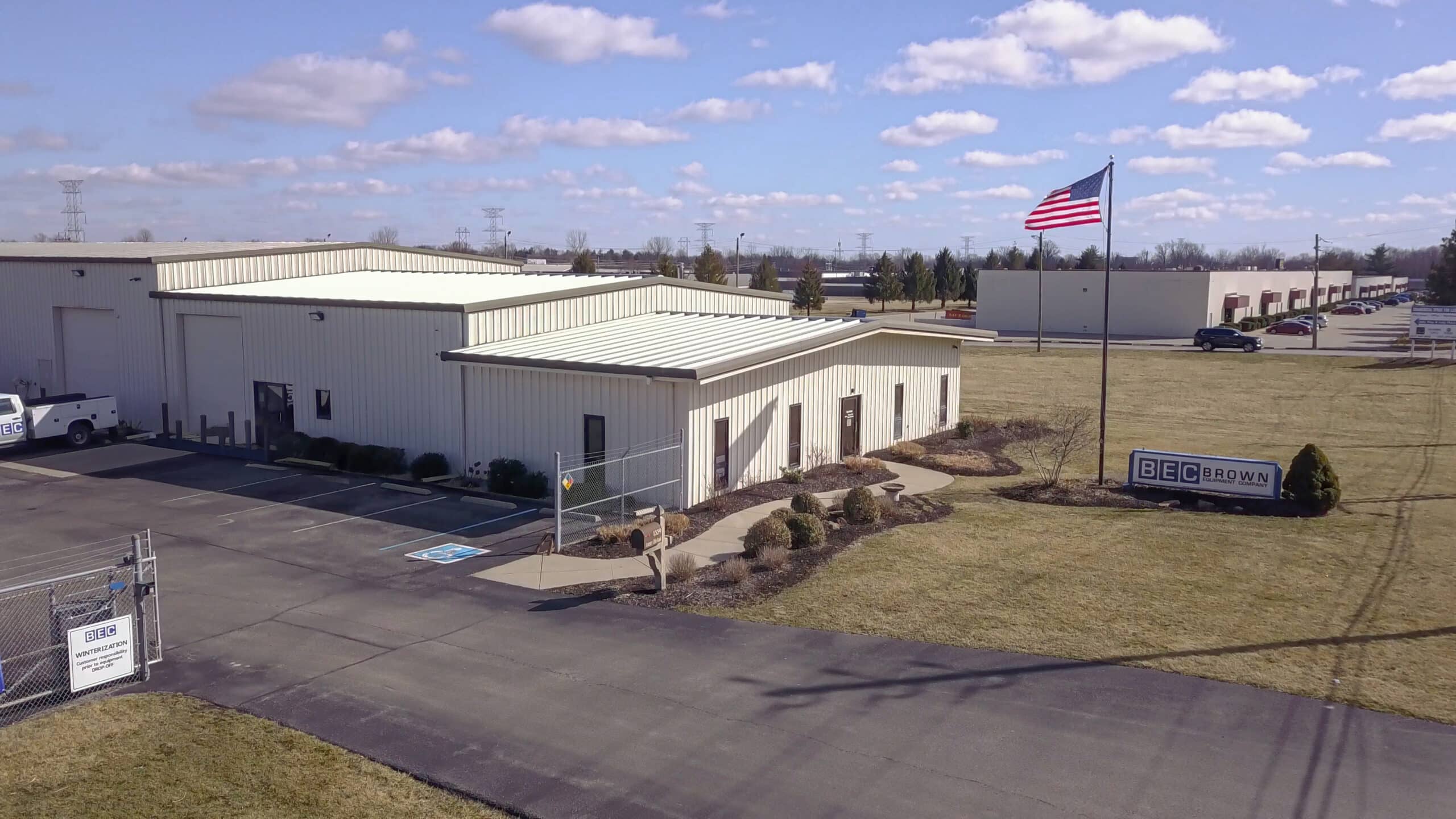 BEC Indianapolis Service Center building exterior under a clear blue sky with American flag.