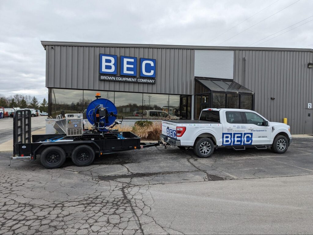 BEC company truck and trailer holding. Sewer easement machine parked outside their modern building.