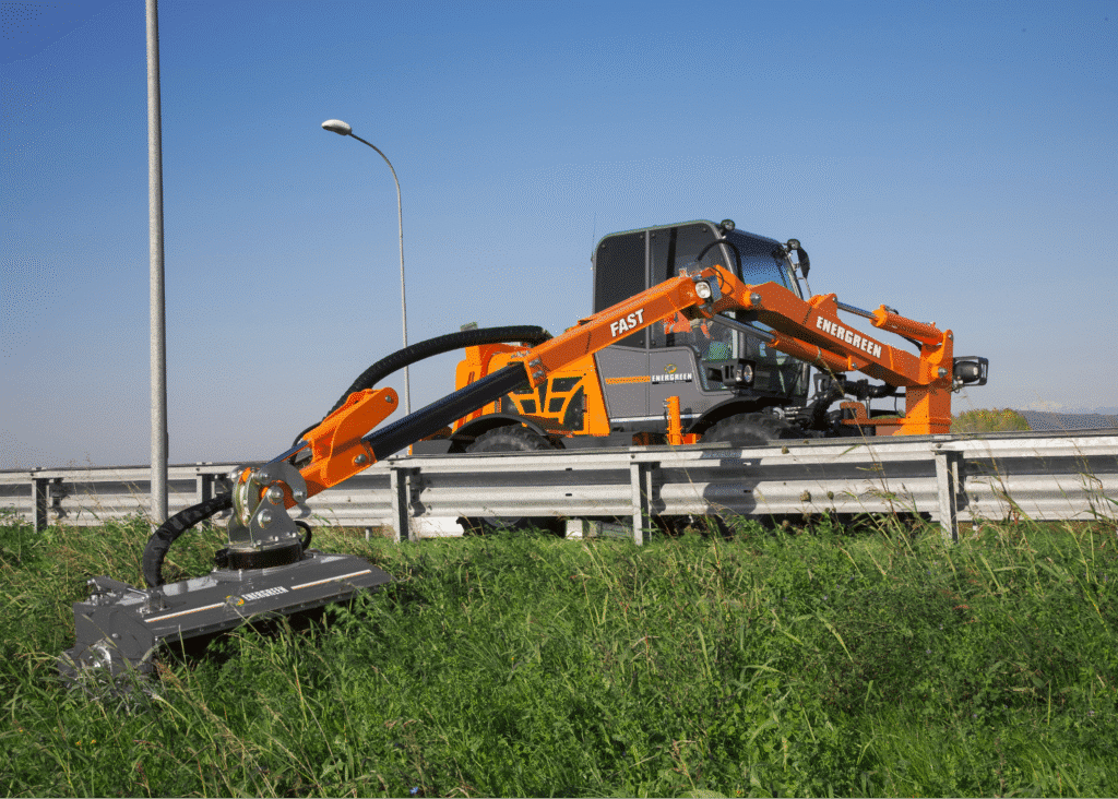 High-tech roadside mower trimming grass near a highway for optimal maintenance.
