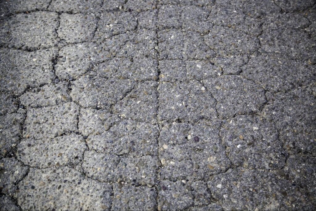 Weathered cracked asphalt surface ideal for road design and maintenance discussions.