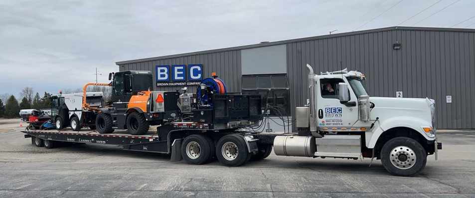 Heavy machinery loaded on truck for transport at BEC facility.