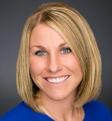 Megan Ainscough, Sales Success Manager, in a blue shirt posing for a professional portrait.