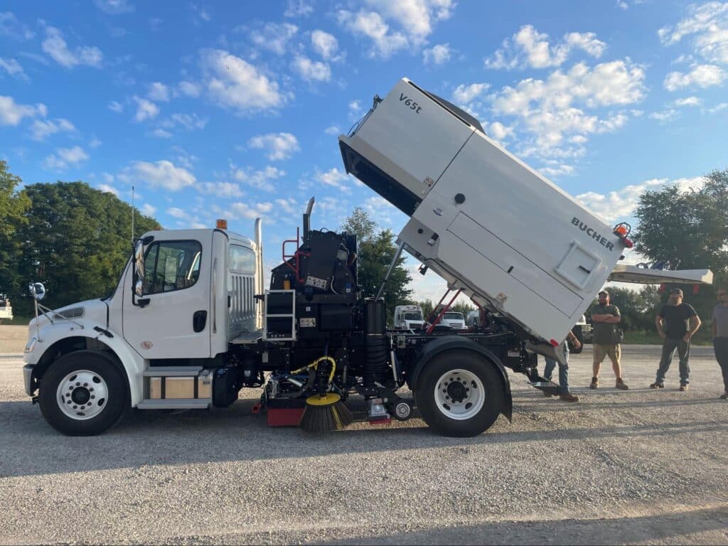 Truck unloading materials efficiently with an elevated hopper for improved performance.