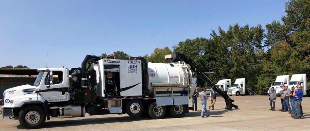 Workers learn about operating an industrial vacuum truck during a training demonstration.