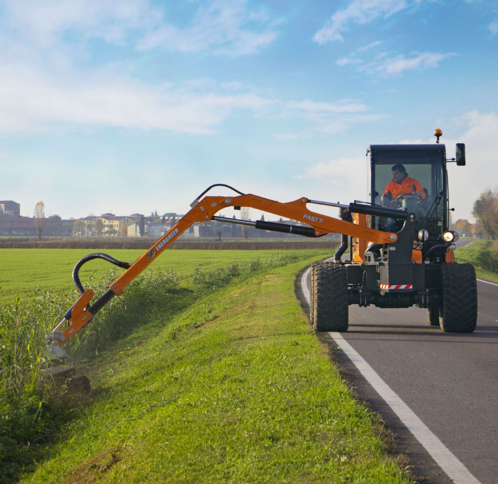 Heavy-duty grass trimming machine efficiently maintaining roadside vegetation.