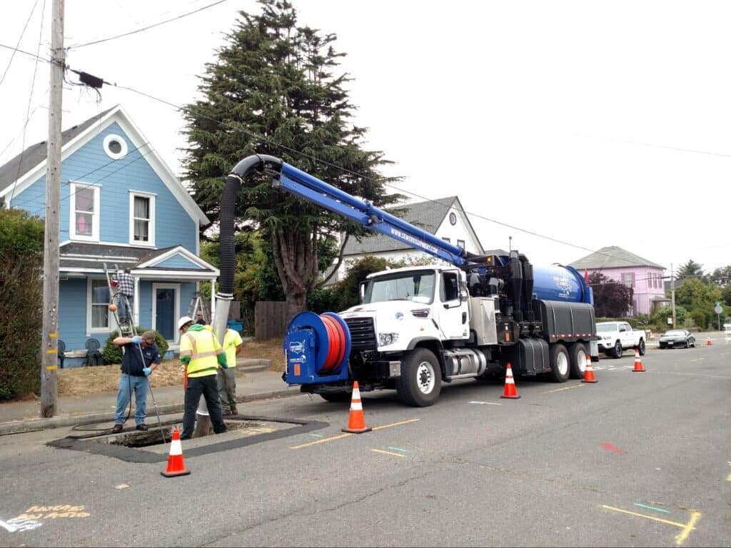 Vacuum truck servicing residential street, ensuring clean and safe environment for homes.