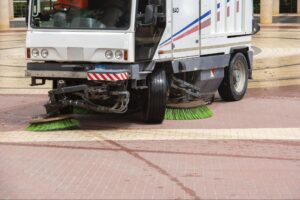 Urban street sweeper cleaning paved surfaces for a cleaner city environment.