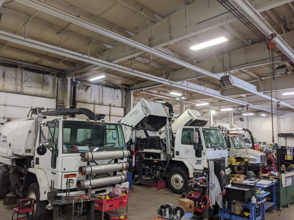 Heavy-duty trucks undergoing maintenance in a well-equipped service garage.