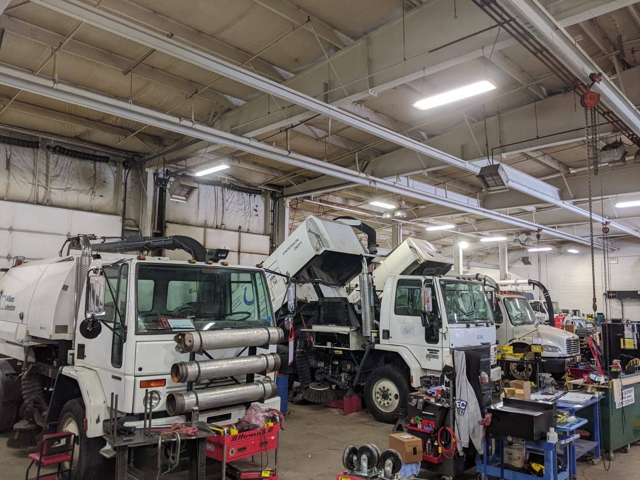 Heavy-duty trucks undergoing maintenance in a well-equipped service garage.
