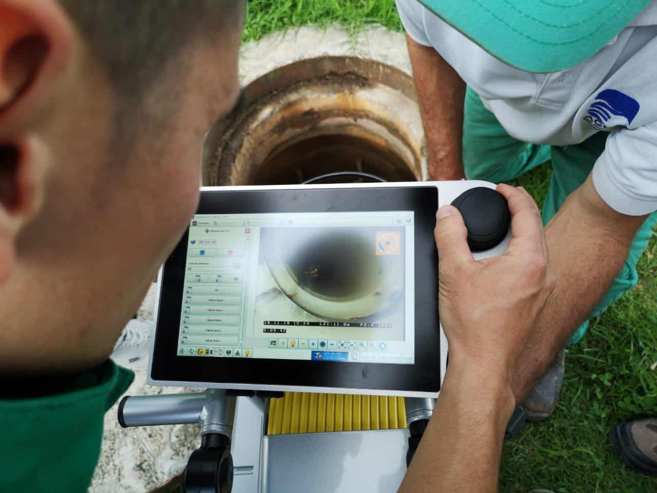 Technicians using tablet technology for advanced sewer pipe inspections.