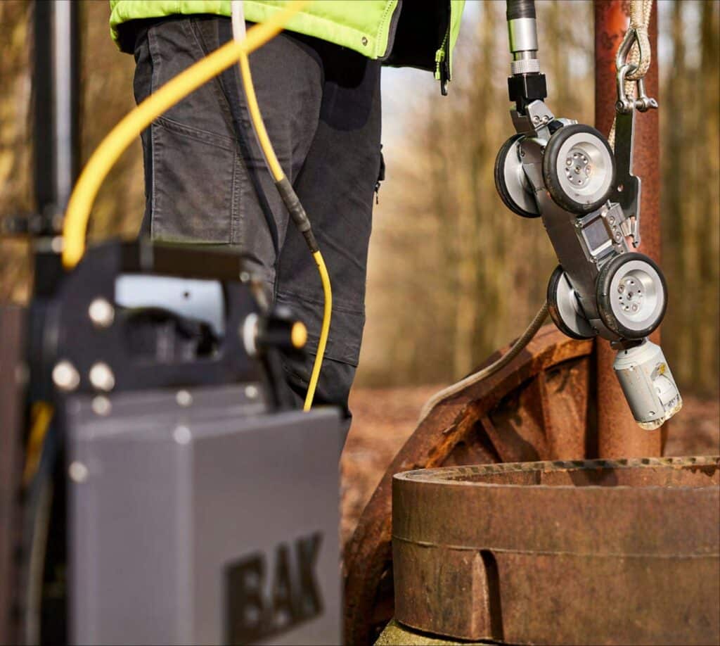Worker inspecting pipeline with advanced equipment for optimal integrity assessment.