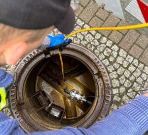 Technician using RapidView technology to inspect a sewer line in a manhole.
